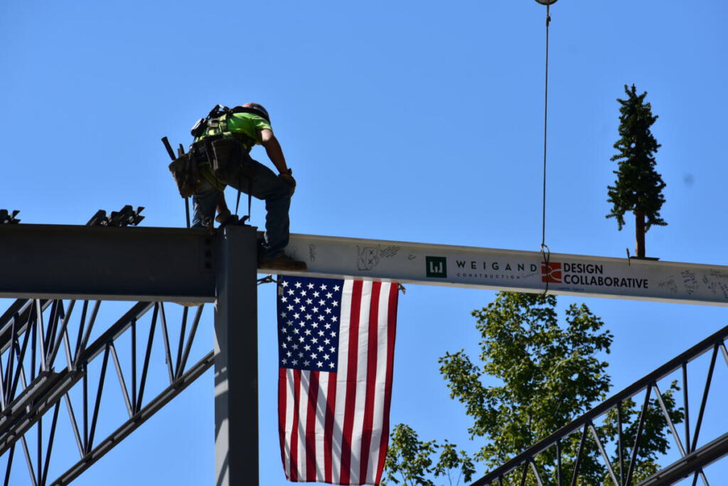 Worker tightening the final beam in place in the frame
