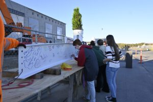 Students signing beam